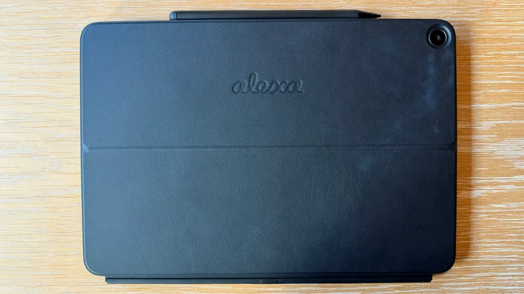 Back of the Alexa Tablet 12 Pro held in one hand, showing the handwritten-style Alexa logo and a single rear camera in the corner.