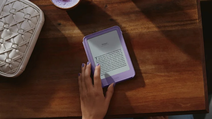 Amazon Kindle on a table, hand navigating the display