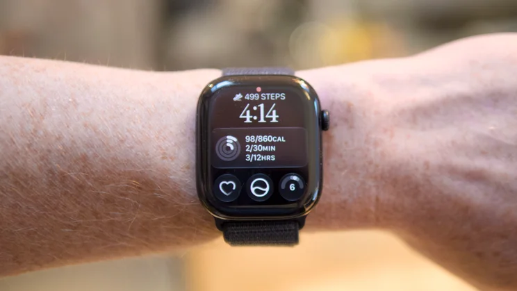 Apple Watch Series 12 on a wrist, showing a watch face with 499 steps, the time 4:14, Activity ring stats and three complications.