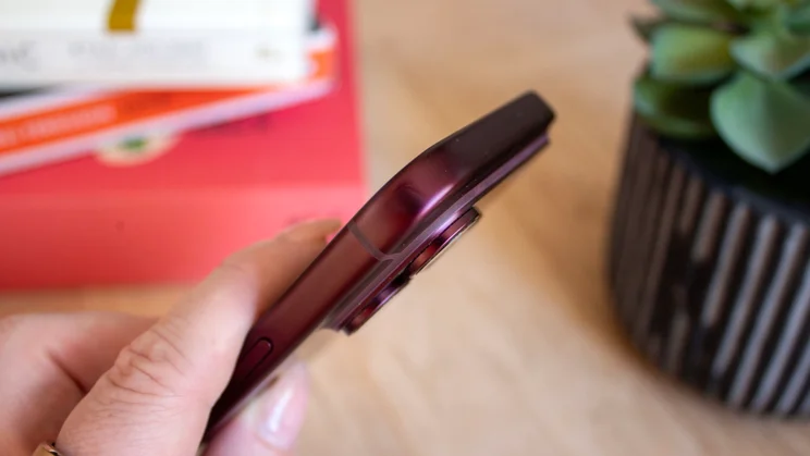Close-up of the top edge of a burgundy iPhone 18 Pro, showing the phone's slim profile and button placement