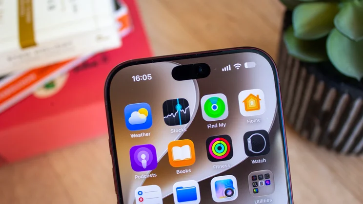 Close-up of the top of an iPhone 18 Pro's home screen, highlighting the front camera cutout above the Weather, Stocks, Find My, and Home app icons