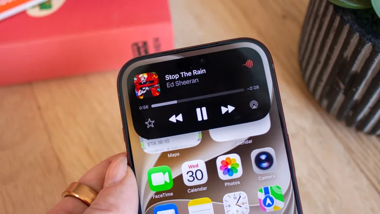iPhone 18 Pro Dynamic Island displaying Apple Music playback controls for 'Stop The Rain' by Ed Sheeran