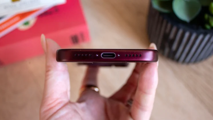 Close-up of the bottom edge of a burgundy iPhone 18 Pro showing the USB-C port and speaker grilles