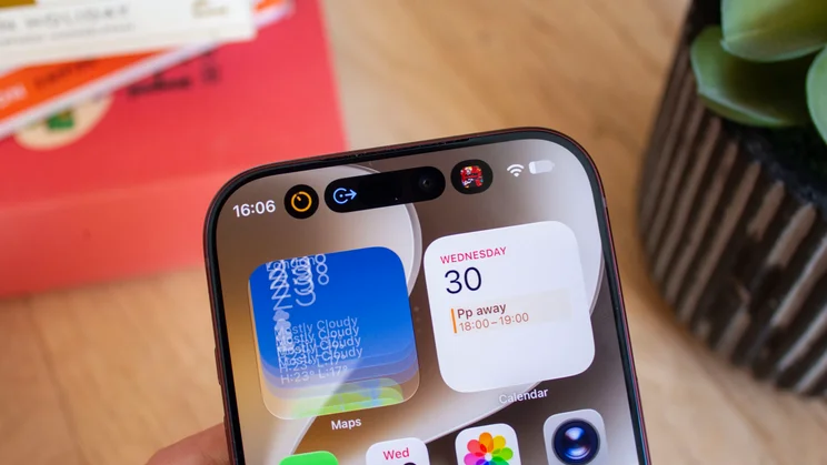 Close-up of an iPhone 18 Pro's Dynamic Island area with an expanded weather widget showing overlapping text, next to a Calendar widget