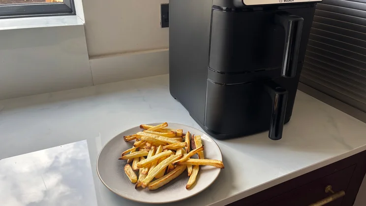 Bosch Series 6 Double Stack Drawer Air Fryer on a kitchen worktop, next to a plate of cooked chips