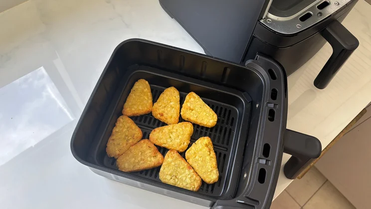 A bird's eye view of cooked hash browns in the Bosch Series 6 Double Stack Drawer Air Fryer's drawer, removed from the appliance