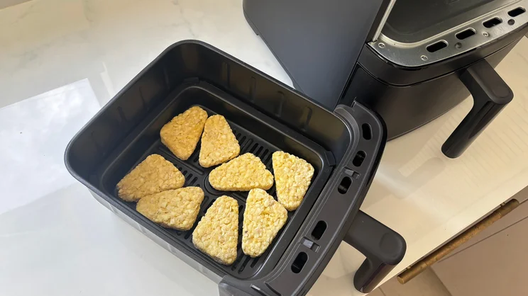 A bird's eye view of uncooked hash browns in the drawer of the Bosch Series 6 Double Stack Drawer Air Fryer