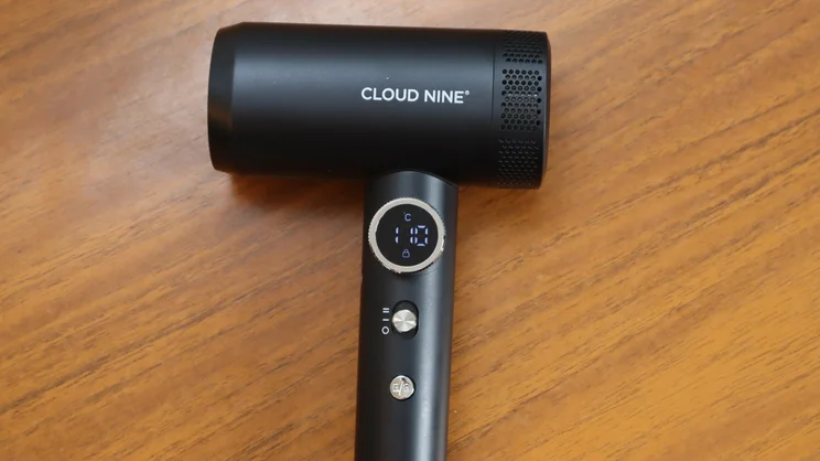 A bird's eye view of the Cloud Nine Airshot Pro Adapt hair dryer, on a wooden table