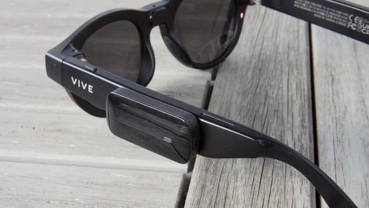 HTC Vive Eagle smartglasses with the power boost module clipped onto the arm beside the Vive logo