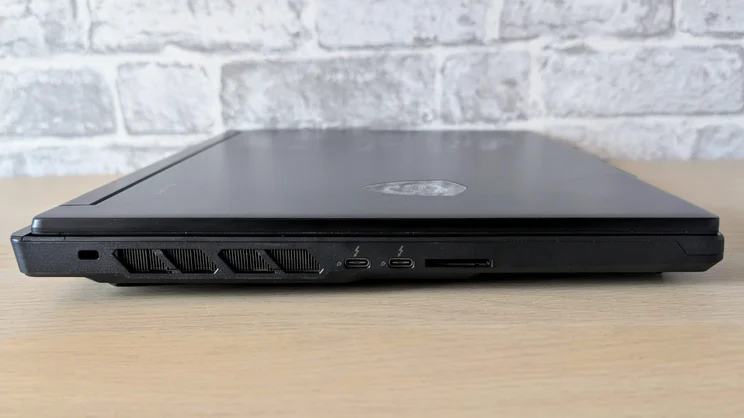 Left side of the closed MSI Raider 16 HX showing a Kensington lock slot, exhaust vents, two Thunderbolt USB-C ports and an SD card reader