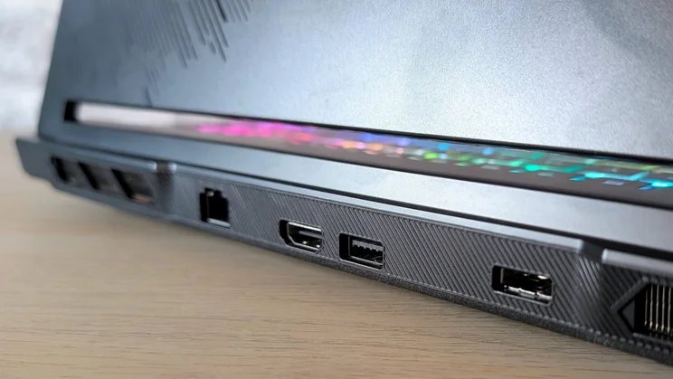 Close-up of the MSI Raider 16 HX rear ports: RJ45 Ethernet, HDMI and USB sockets, with the RGB light bar glowing above