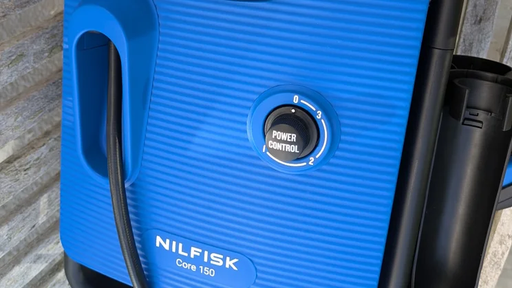 Close-up of the Nilfisk Core 150 PowerControl blue ribbed front, showing the black Power Control dial marked 0 to 3 and the Nilfisk Core 150 badge.
