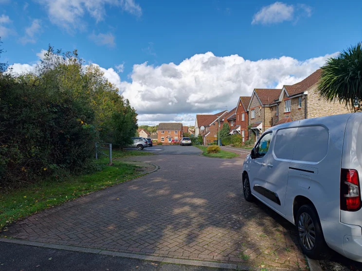A quiet close of houses with cars parked out front