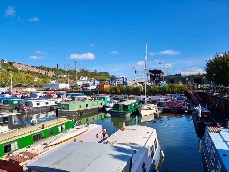 A busy marina filled with boats, buildings in the distance