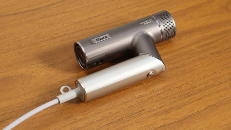 A bird's eye view of the Shark Speedstyle Pro Flex hair dryer, folded up, on a wooden table