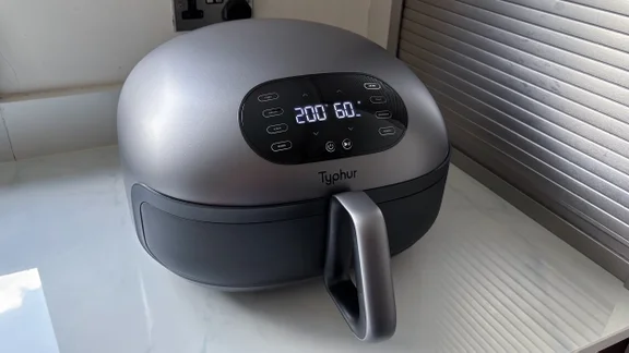 The Typhur Dome 2 air fryer, its digital display on, on a kitchen countertop