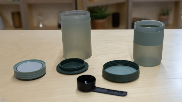 Separate parts of the Wacaco Prestina coffee maker arranged on an office table