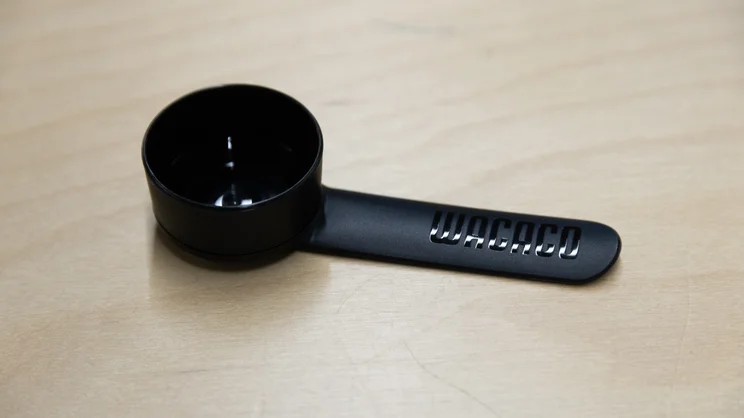 A closeup of the Wacaco Prestina coffee maker's stir-spoon, on an office table