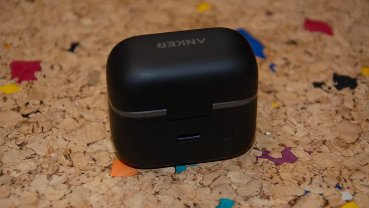 Rear view of the closed black charging case for the Anker Soundcore AeroClip 2 clip-on earbuds, highlighting the lid hinge, USB-C charging port, and pairing button
