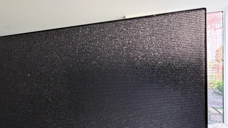 Close-up shot showing the brushed, horizontal-grain textured pattern on the upper back panel of the 77in LG C6 OLED TV with Primary RGB Tandem OLED technology