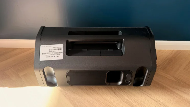 A top-down view of the rear and handle section of the LG xboom Stage 501 speaker lying on its side on a wooden floor