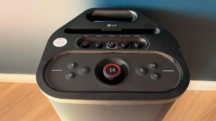 The top control panel of the LG xboom Stage 501 speaker, featuring control knobs, buttons, and a central circular play/pause dial