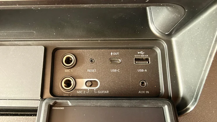 A close-up view of the input panel on the LG xboom Stage 501, showing microphone, guitar, USB-C, USB-A, AUX IN ports, and a reset button