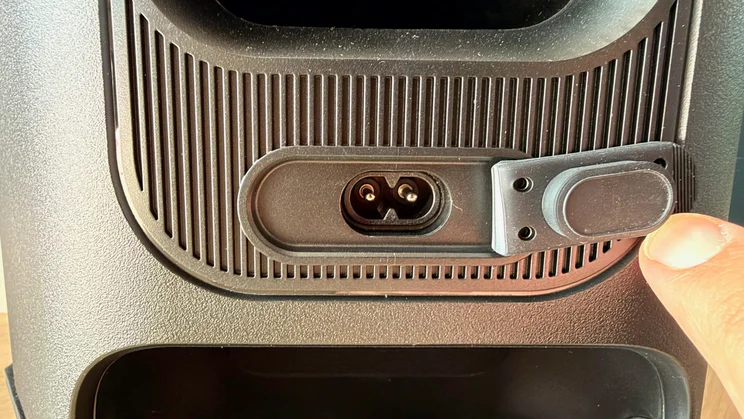 A close-up view of the 2-pin figure-8 mains power socket on the LG xboom Stage 501, with its protective rubber flap held open