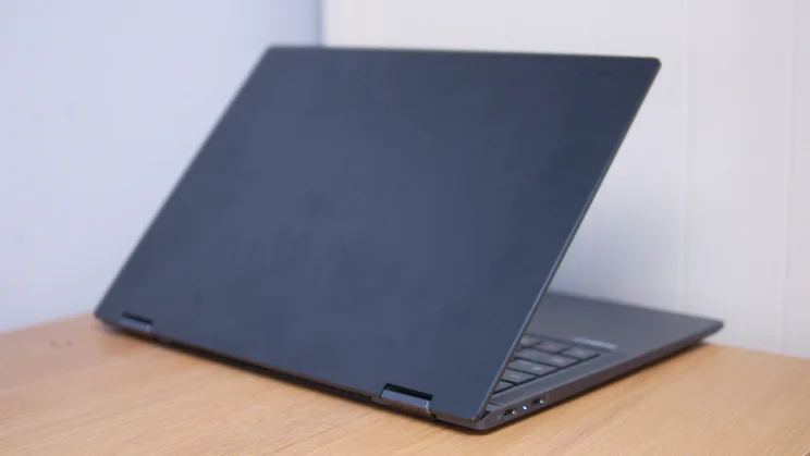 Back of the Acer Googlebook 14 lid in a dark blue-grey finish, propped half open on a wooden table, with two USB-C ports on the side.