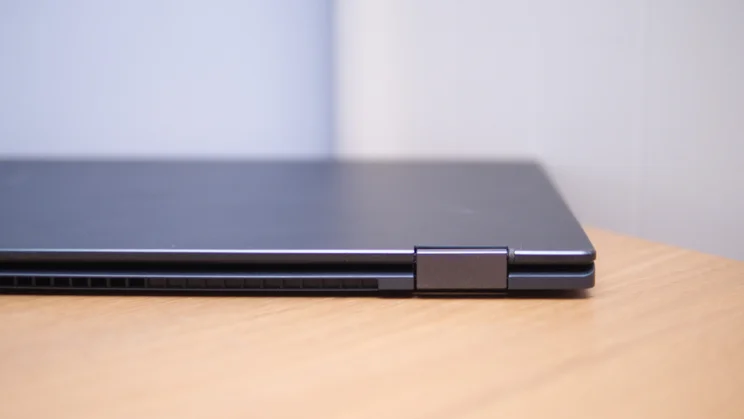 Rear edge of the closed Acer Googlebook 14 on a wooden desk, showing the metal hinge and a row of cooling vents.