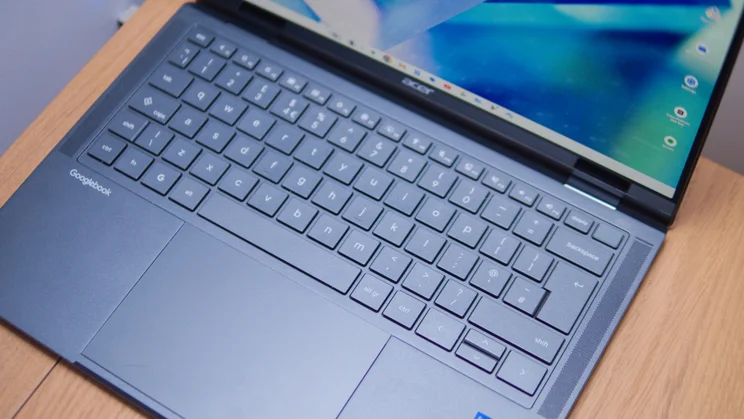 Angled view of the Acer Googlebook 14 keyboard and trackpad on a wooden desk, with the Googlebook name at the left and the screen above.