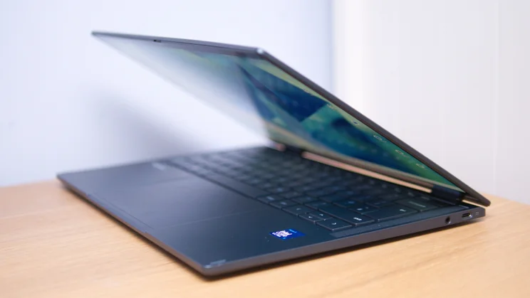 Side view of the Acer Googlebook 14 partly open on a wooden desk, showing the slim body, a USB-C port, a headphone jack and an Intel Core Ultra sticker.