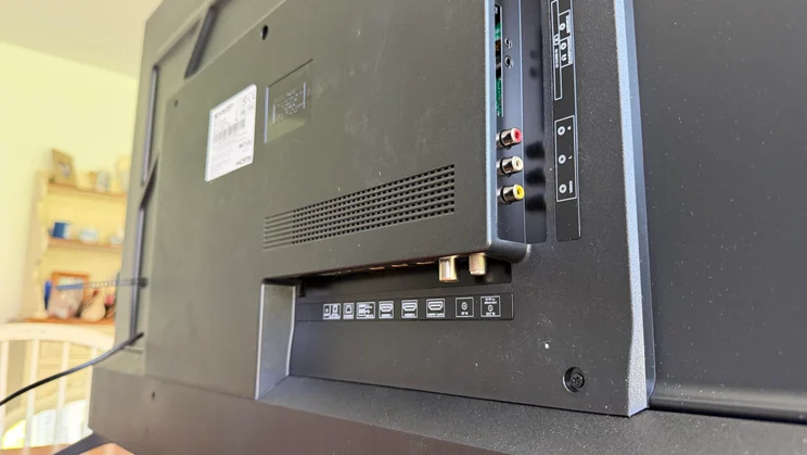 Angled close-up of the rear input panel on the Sharp HJ6725KB Roku TV, showing HDMI, USB, AV input jacks, antenna, and audio connection ports