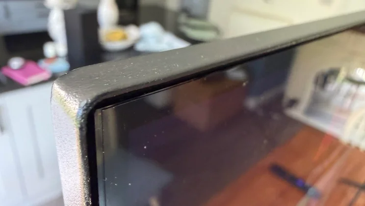 Extreme close-up of the top corner frame and slim bezel border of the Sharp HJ6725KB Roku TV display