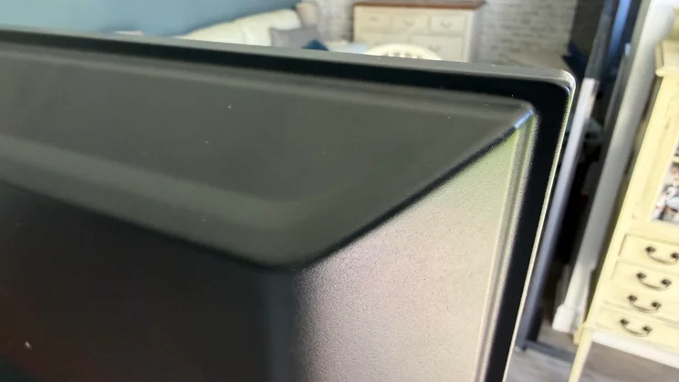 Close-up shot from behind showing the top-right corner bevel and smooth plastic finish of the Sharp HJ6725KB Roku TV frame
