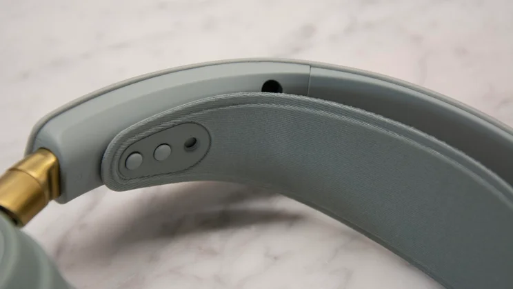 A close-up detail of the inner headband and elastic suspension strap adjustment points on the SteelSeries Arctis Nova Elite gaming headset, adjacent to a gold hinge