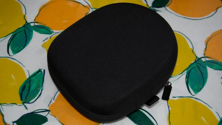 Closed black zippered hard-shell carrying case designed for the Technics EAH-A1000 headphones, resting on a lemon-patterned tablecloth