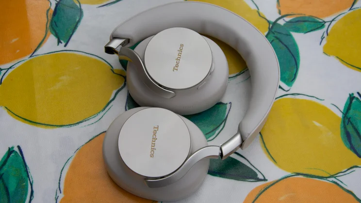Greige Technics EAH-A1000 over-ear headphones folded inward at the hinges into a compact configuration for travel
