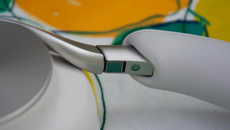 Close-up detail of the metal folding hinge mechanism connecting the headband to the earcup arm on the Technics EAH-A1000 headphones