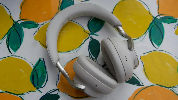 Technics EAH-A1000 wireless headphones resting on their side on a lemon-patterned fabric, showing the padded headband and inner cushioned ear cups