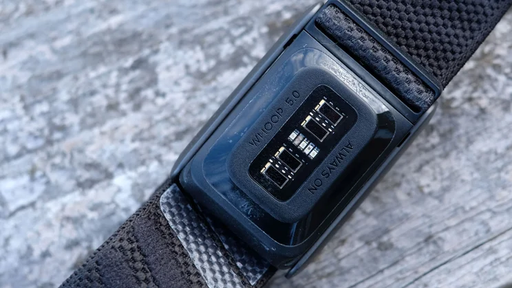 Close-up of the Whoop 5.0 sensor side, showing its LEDs, photodiodes and the Whoop 5.0 text