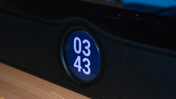 Close-up of the WiiM Bar soundbar's circular display showing a digital clock readout