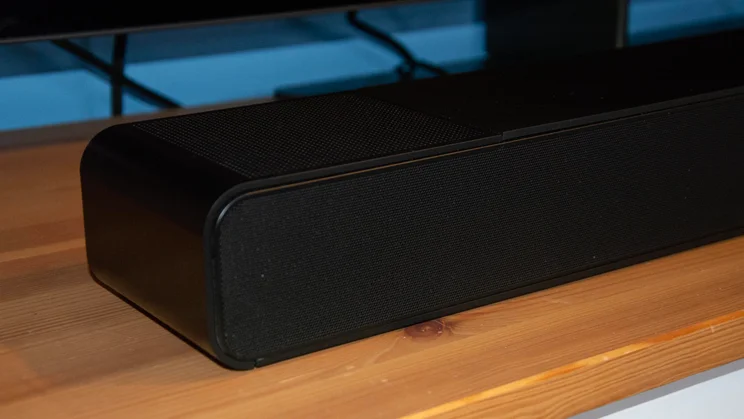 Close-up angled view of the left corner and mesh speaker grille of the black WiiM Bar soundbar